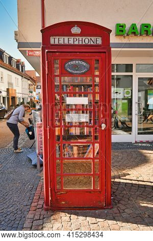 Hofheim, Germany - March 2020: Public Bookcase In Old Red Telephone Box. A Cabinet Which May Be Free