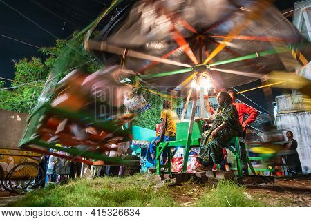 Howrah, West Bengal, India -14th April 2019: Aged Woman Watching Over Children Riding On Nagordola- 