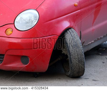Torn Off Wheel Of A Red Passenger Car Due To A Broken Ball Bearing