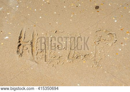 The Word Help Written In The Sand In Capital Letters. The Concept Of A Call For Help. High Quality P