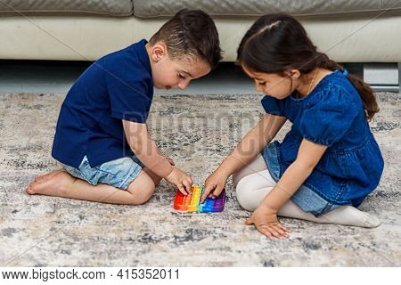 Two Cute Children Playing With The Pop It Fidget. Push Pop Bubble Flexible Fidget Sensory Toy Provid