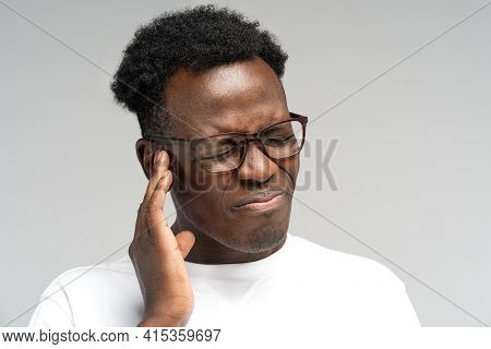 Sick African American Millennial Man Suffering From Tinnitus, Throbbing Earache, Tired Of Noise. Irr