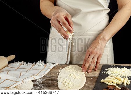 A Flattened Dough On Wood Kitchen Countertop. A Bread Making Concept Image With Loafs,  Cheese And S