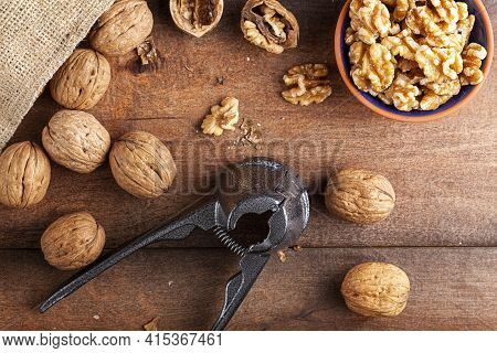 Flat Lay Image Showing A Cast Iron Walnut Pliers ( A Nutcracker Tool) With Raw Fresh Walnuts In Shel