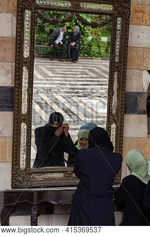 Damascus, Syria 03-28-2010: A Young Arabic Woman Is Standing In Front Of A Mirror Putting On Niqab M