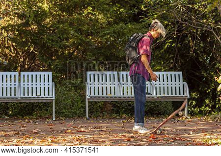 Frederick, Md, Usa 10/14/2020: A Teen Boy With Stylish Blond Hair Wearing Jeans And Sneakers Is Step