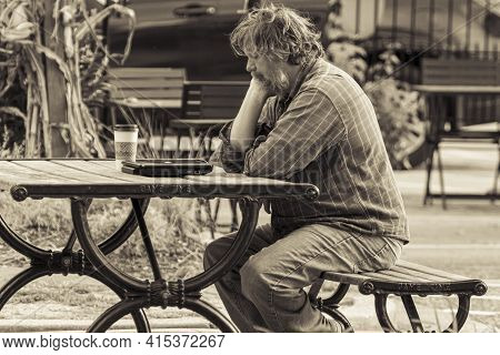Ellicott City, Md, Usa 10/07/2020: Black And White Image Of An Elderly Unkempt Man Sitting Alone On 