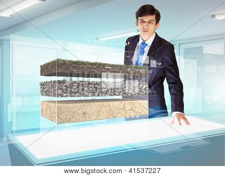 Image of young businessman looking at high-tech picture of topsoil