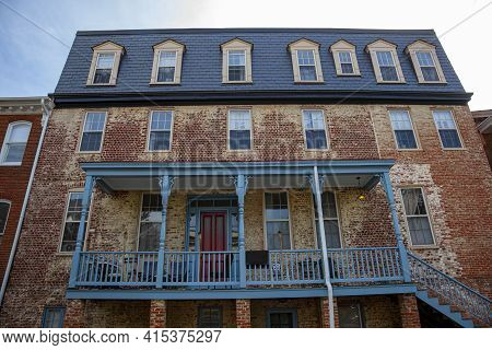 A Run Down Large Vintage House With Discolored Brick Exterior Located In The Historic District Of An
