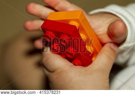 Close Up Image Of An Infant Baby's Hands As He Or She Is Trying To Interlock Two Toy Bricks. Image I