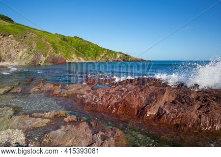 Red Coloured Rocks And Clear Sea Talland Bay Cornwall England Uk