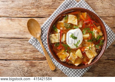 Delicious Soup With Vegetables, Ground Beef, Homemade Noodles And Poached Egg Close-up In A Bowl On 