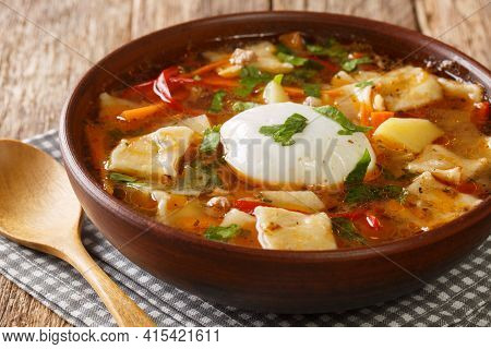 Delicious Soup With Vegetables, Ground Beef, Homemade Noodles And Poached Egg Close-up In A Bowl On 