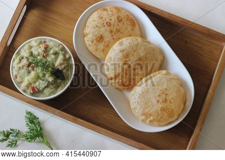 Deep Fried Indian Flat Bread Served With Mixed Vegetable Curry In A Coconut Cashew Gravy