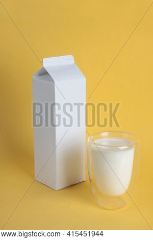 Fermented Milk Concept - White Pack And Glass Of Kephir Isolated On Yellow Background. Image Contain