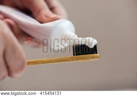Woman Will Squeeze The Toothpaste From The Tube Onto The Toothbrush Close Up.