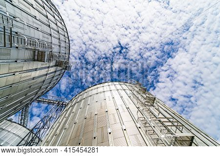 Special Grain Elevators For Crop Storage. Metal Bridge From The Roof Of Metal Tank. View From Below.