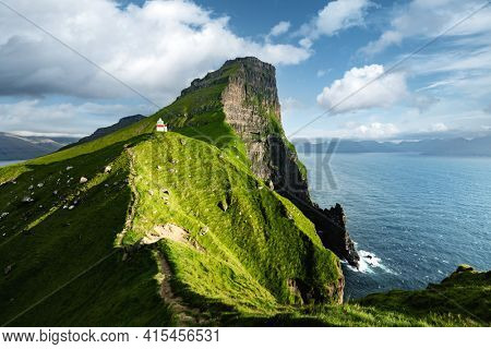 Kallur lighthouse on green hills of Kalsoy island