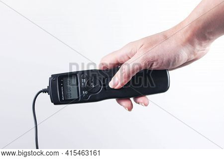 Hand Holding Remote Control Shutter Switch Of Dslr Mirrorless Camera On White Background.