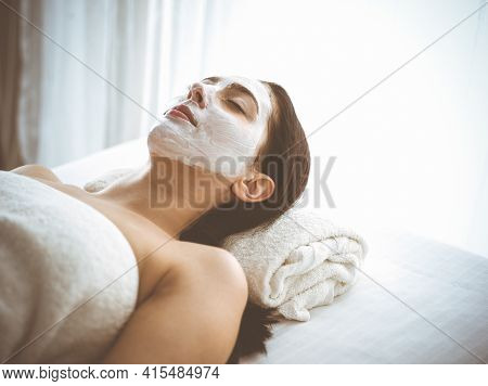 Beautiful Brunette Woman Enjoying Applying Cosmetic Mask With Closed Eyes Comfortable And Blissful. 