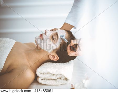 Beautiful Brunette Woman Enjoying Applying Cosmetic Mask With Closed Eyes Comfortable And Blissful. 