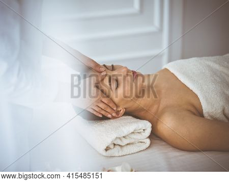 Beautiful Brunette Woman Enjoying Facial Massage With Closed Eyes Comfortable And Blissful. Relaxing