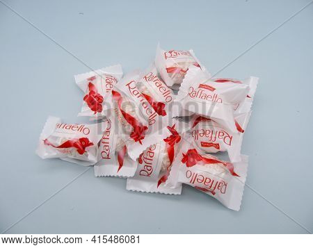 Rafaello Candy Wrapper On A Blue Background Among Flowers