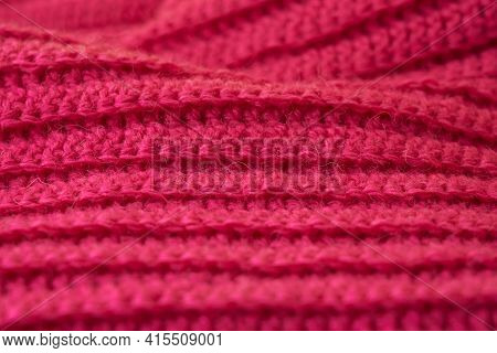 The Structure Of A Knitted Canvas Of Pink Wool Threads.