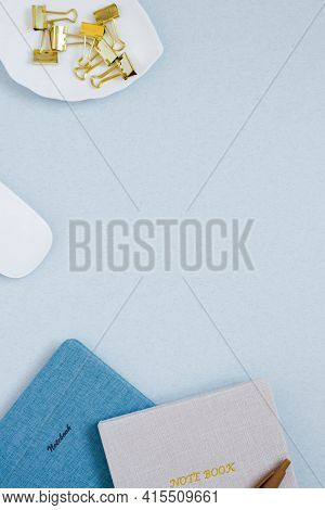 Stationery Clips And Notepads With A Pen On A Blue Desk. The Desktop Of A Blogger Or Stu. Copy Space