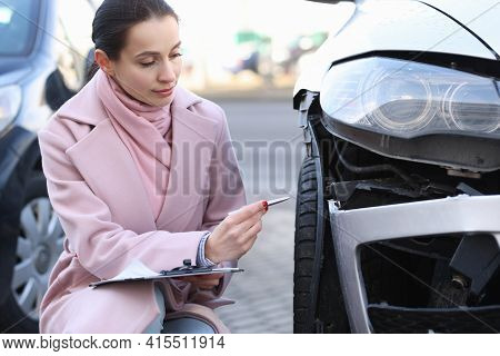 Insurance Agent Holds Estimate Of The Value Of Damaged Vehicle