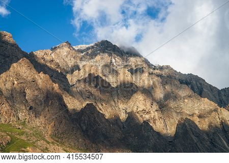 Scenic Mountain Landscape With Great Rocks In Golden Sunlight And Low Clouds. Awesome Rocky Wall Wit