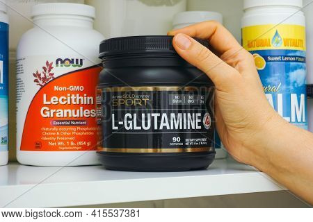 Tambov, Russian Federation - January 25, 2021 Woman Hand Taking Jar Of L-glutamine By California Gol