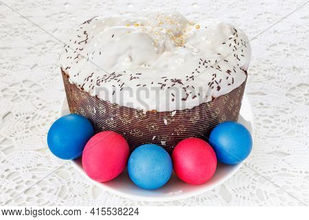 Easter Cake With Glace Icing And Easter Eggs On White Lace Tablecloth.  
Traditional Christian Easte