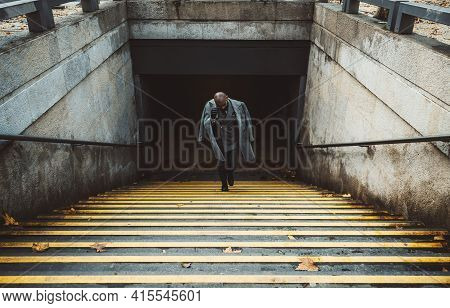 View Of An Elegant Bald Man Entrepreneur Climbing The Stairs With Yellow Lines From The Metro Statio