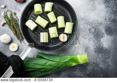 Raw Braised Leeks On Grill Pan Uncooked With Herbs Ingredients , On Textured Grey Background Top Vie