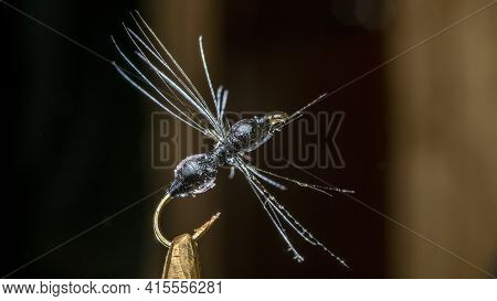 Imitation Of Ant. Handmade Fishing Fly Tied Close-up On A Dark Background.