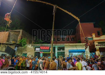 Howrah, West Bengal,india - 15th April 2019: Two Hindu Devotees Are Hanging From Pole In Air, At Nig