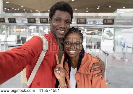 Happy African American Couple Taking Selfie At Airport Terminal, Ready For Travel, Looking At Camera