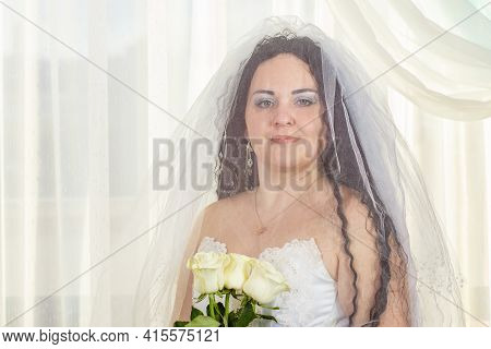 Jewish Bride With A Veil Before The Chuppa Ceremony With A Bouquet Of White Roses In Her Hands.