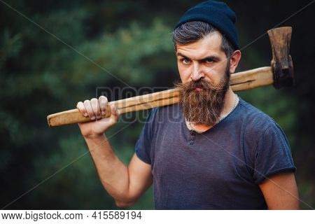 A Stern Look Of A Man With A Thick Beard And A Large Mustache In A Dark Sleeveless T-shirt And A War