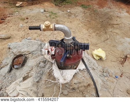 Closeup Of Exterior View Of Bore Well Outside Metal Pipe In A Empty Field For Water Flow