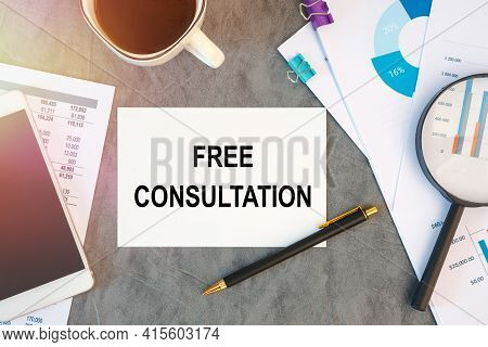 Free Consultation Is Written In A Document On The Office Desk With Office Accessories, Coffee, Diagr