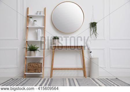 Console Table With Shelving Unit And Mirror On White Wall In Hallway. Interior Design