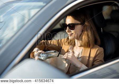 Beautiful Woman Eating Heathy Salad In The Car. Received A Food Order To Go. Have A Quickly Snack On