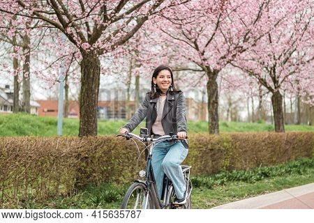 Beautiful Young Woman Of Mixed Races Minority Riding On Bicycle In Bloomy Spring In Casual Clothes W