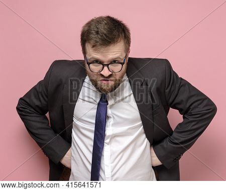 Caucasian Bearded Man In Glasses And A Business Suit Is Embittered And Looks Furiously Into The Came