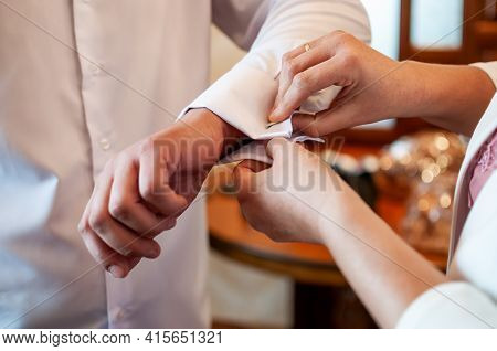A Groom Fastening A Cuff-link Before Getting Married