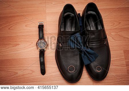 Shoes And Wristwatch Lie Down On The Table