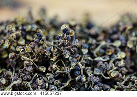 Dried Brown Andaliman Pepper On Olive Wood