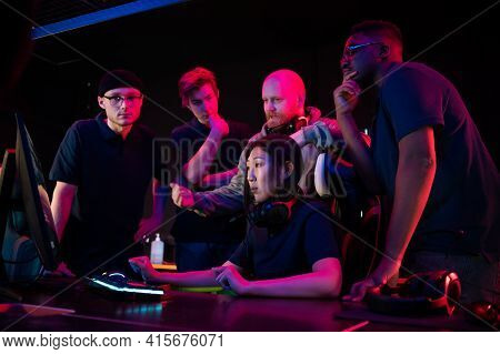 A Cyber Team Of Guys And A Coach Explains Their Strategy To A New Team Member An Asian Girl